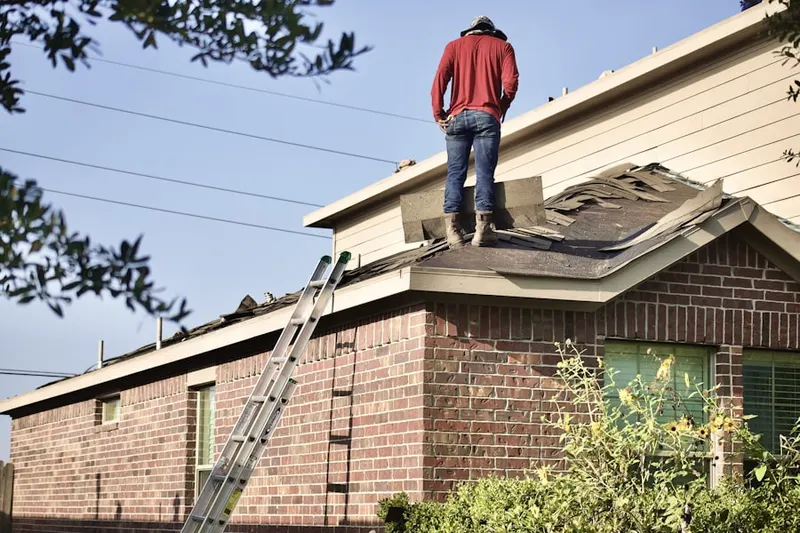 Professional roofer working on a residential roof in East Bay